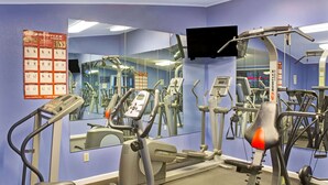 A gym with exercise equipment, a large mirror, and a poster on the wall. - Days Inn by Wyndham Lawrenceville (Lawrenceville)