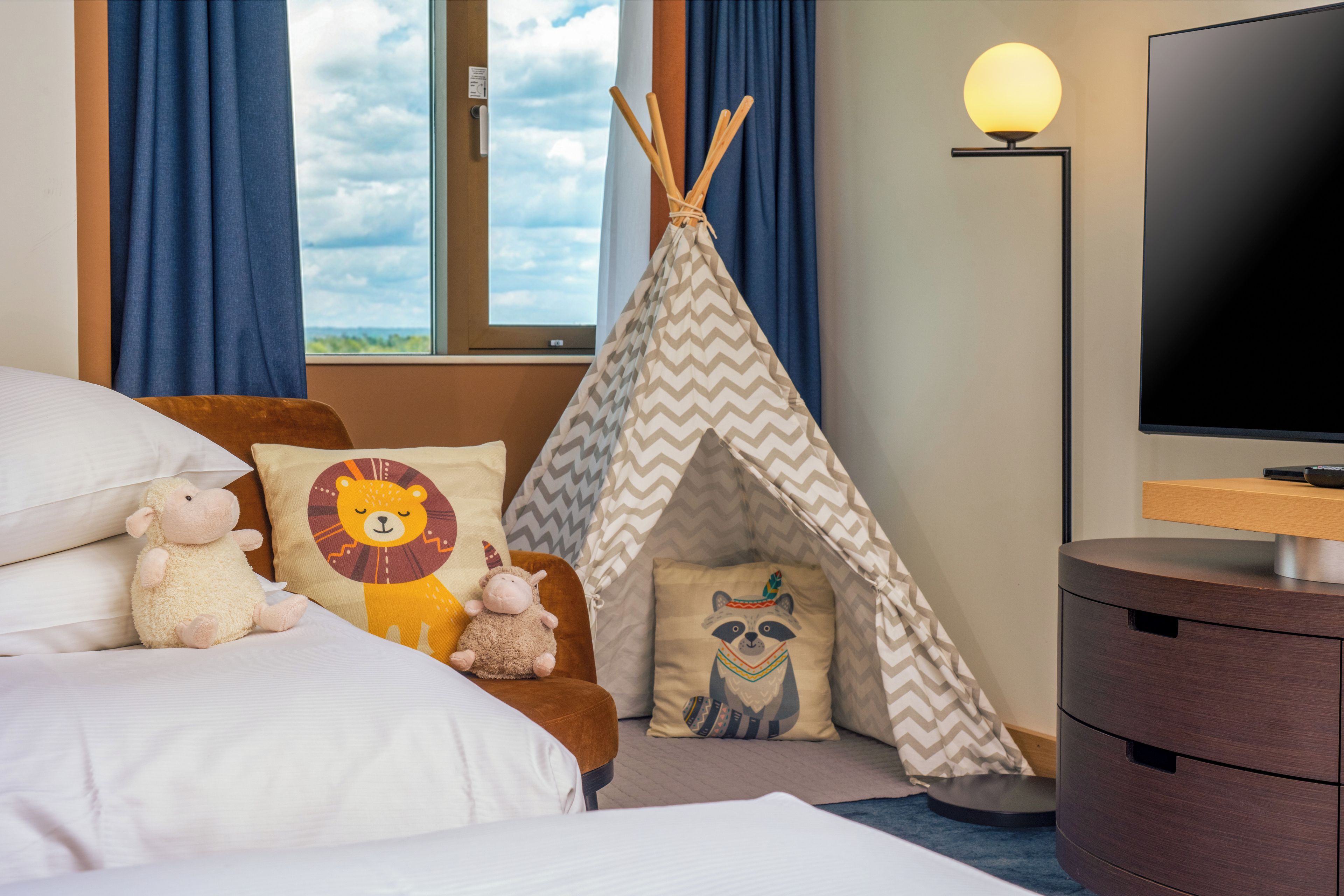 Une chambre d’hôtel avec un lit, une tente amérindienne et un téléviseur.