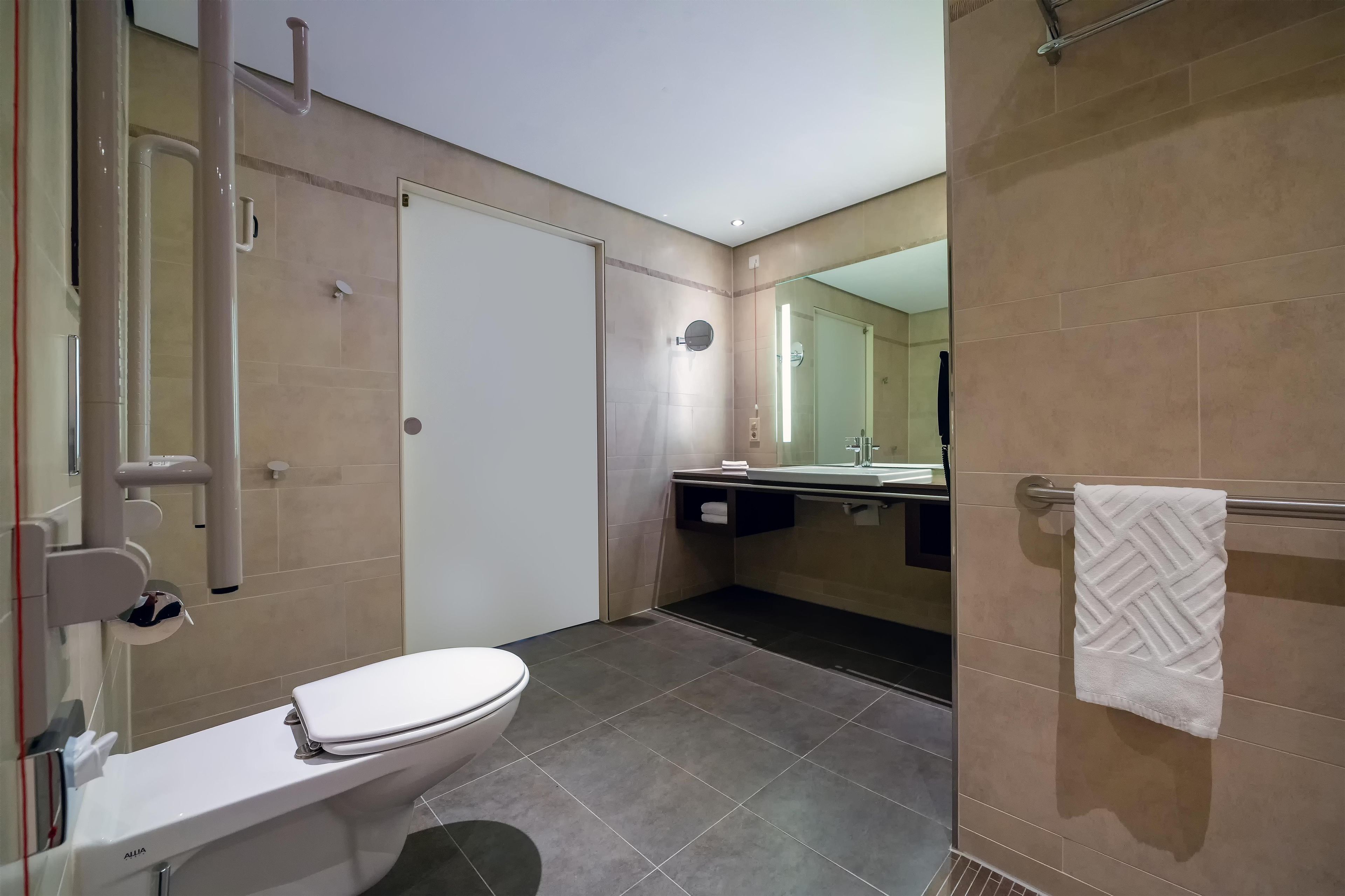 A modern bathroom with a toilet, sink, and shower area.