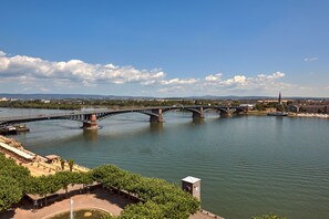 A river with a bridge, a park area, and a distant church spire.
