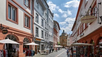 Una calle adoquinada con tiendas y mesas al aire libre.