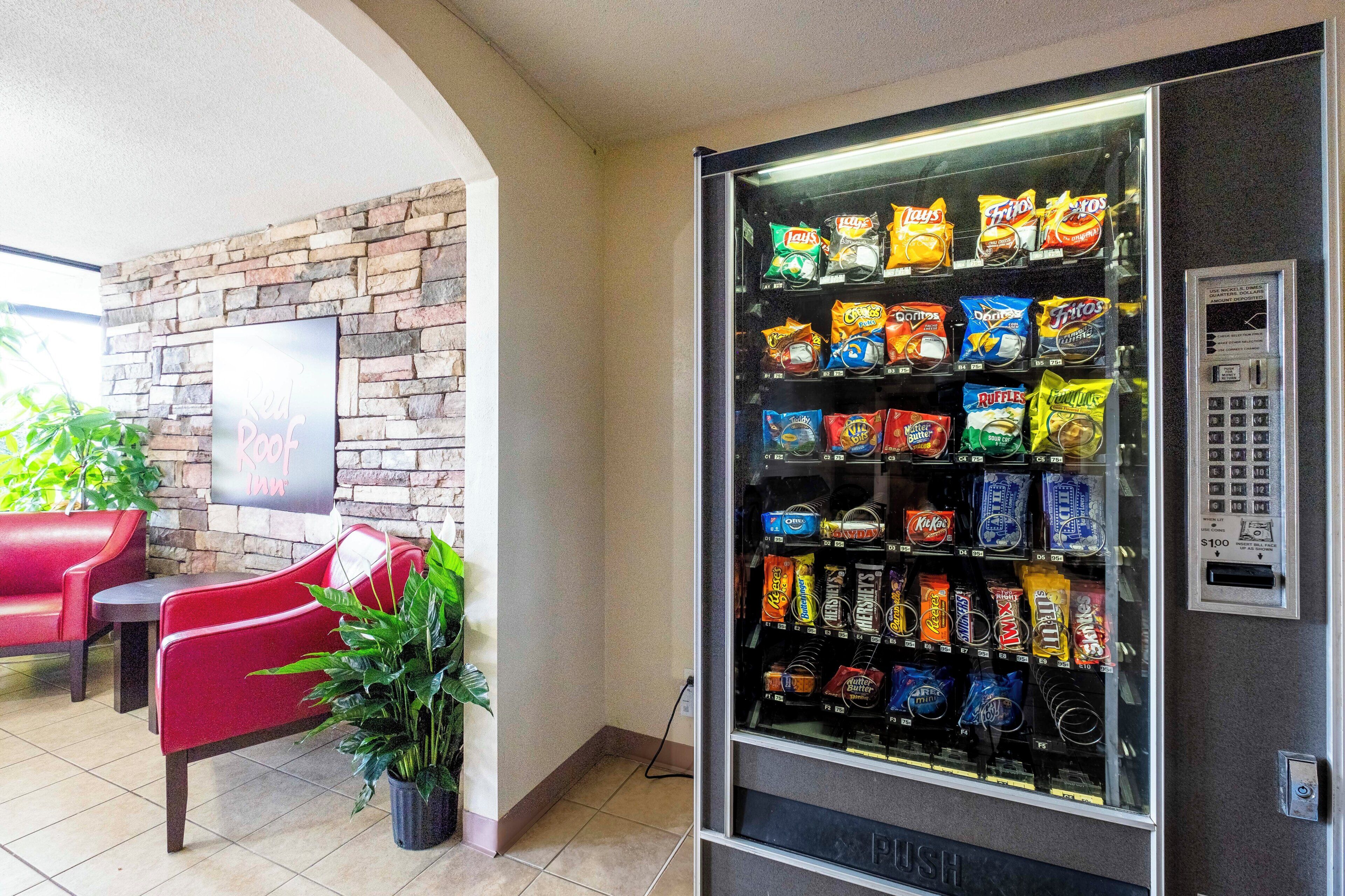A vending machine with snacks, a brick wall, and a Red Door Inn sign.