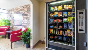 A vending machine with snacks, a brick wall, and a Red Door Inn sign. - Red Roof Inn Kenly – I-95 (Kenly)