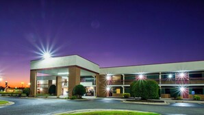 A multi-story hotel with a flat roof and a parking lot in front. - Red Roof Inn Kenly – I-95 (Kenly)
