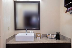 A bathroom with a white sink, a mirror, and a coffee machine on the countertop. - Red Roof Inn Kenly – I-95 (Kenly)