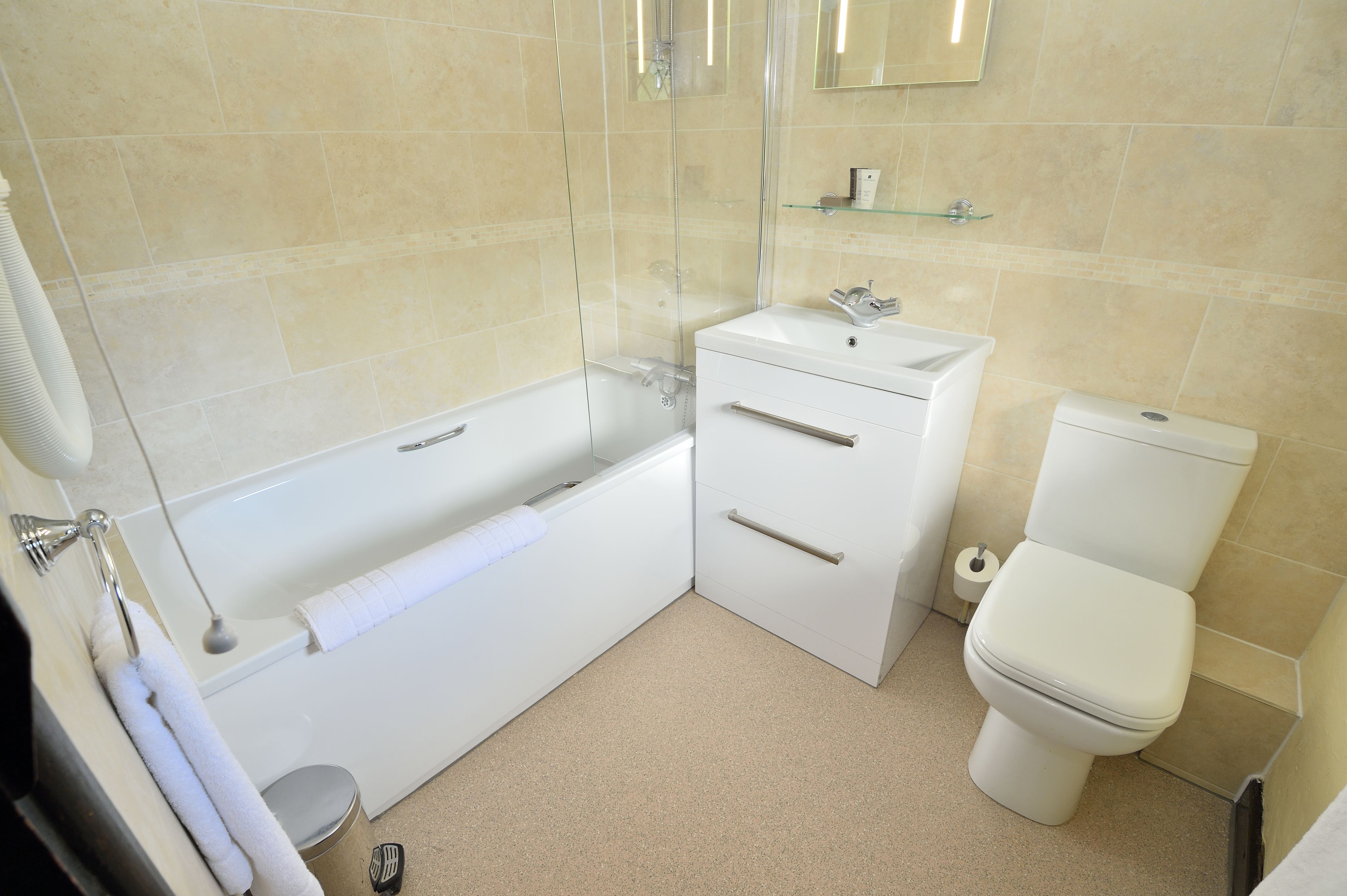 Ein modernes Badezimmer mit Badewanne, Toilette und Waschbecken.