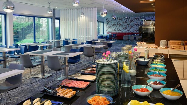 A buffet setup with various food items and a seating area with tables and chairs. - Novotel Gdansk Centrum (Gdansk)
