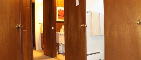 A hallway with wooden doors leading to a bathroom.