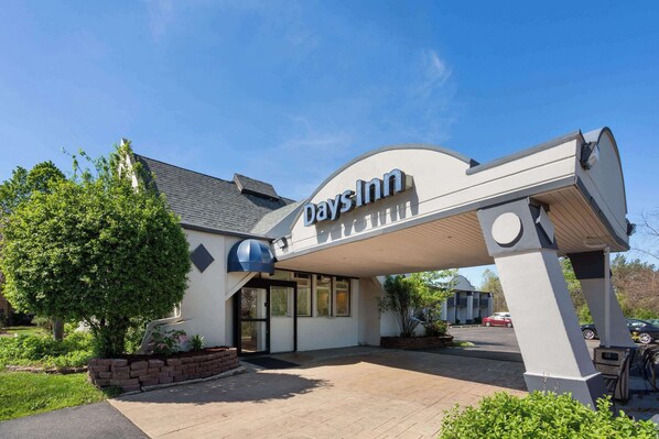 Welcome to Days Inn, featuring a convenient entrance with double doors and a charming planter with a tree.