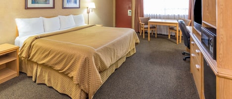 Une chambre d’hôtel avec un grand lit, un bureau, une chaise, une télévision et une armoire.