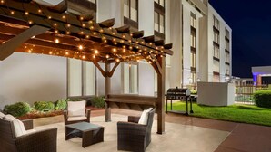 An outdoor patio with wicker furniture, a pergola with string lights, and a barbecue grill. - La Quinta Inn & Suites by Wyndham Dothan (Dothan)