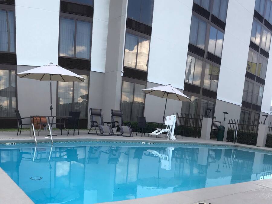 Una piscina al aire libre de temporada, sillones reclinables de piscina