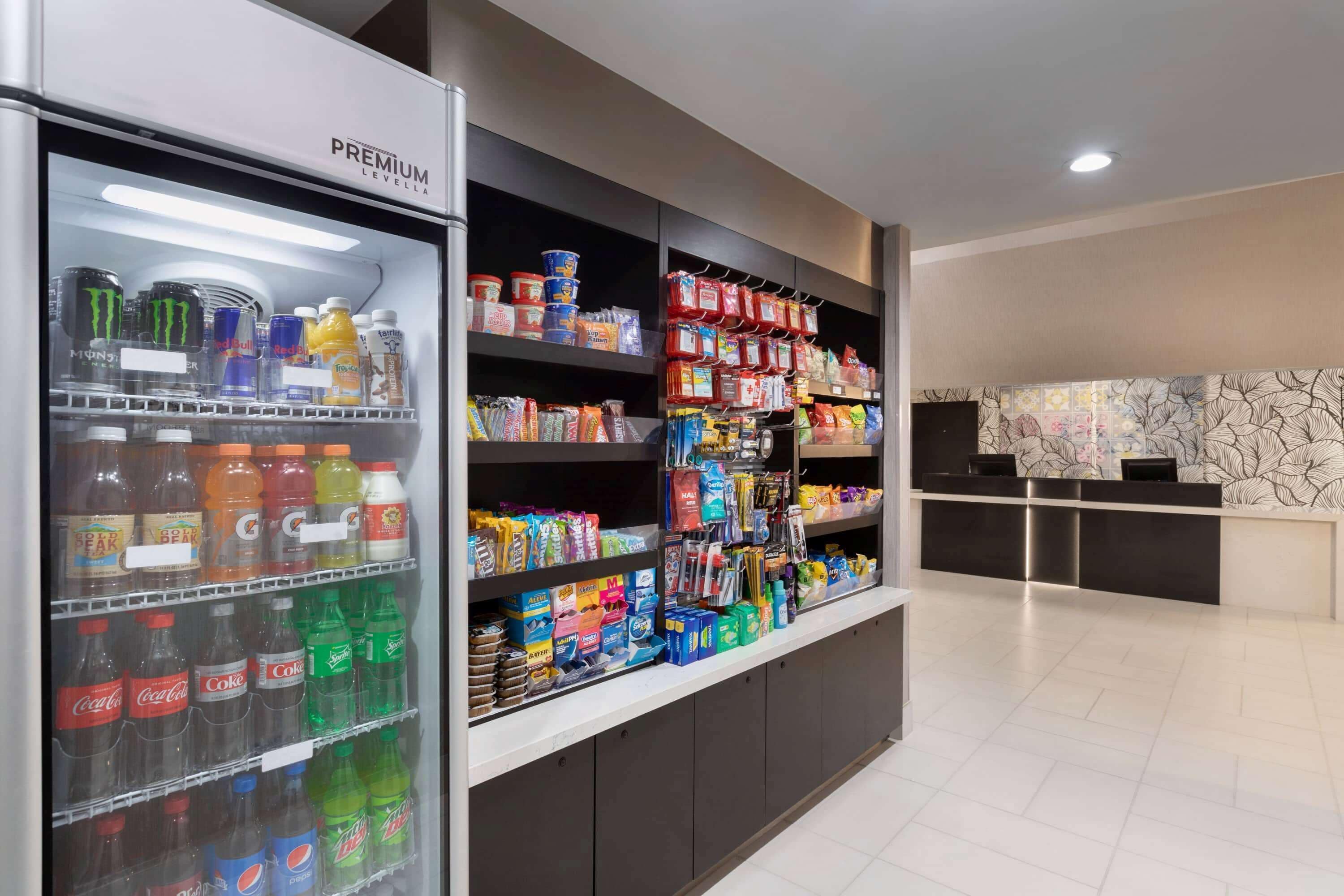 Un'area di accoglienza in un hotel, con un banco frigo per bevande e scaffali per snack.