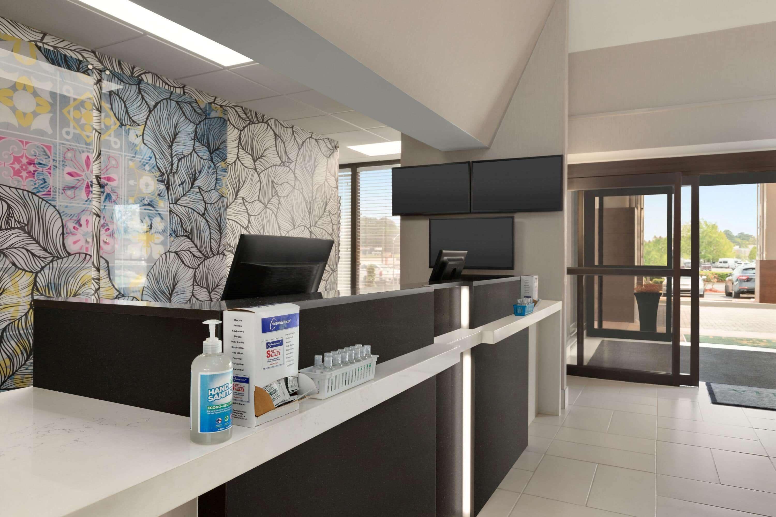 A reception area with a counter, hand sanitizer, and informational brochures.