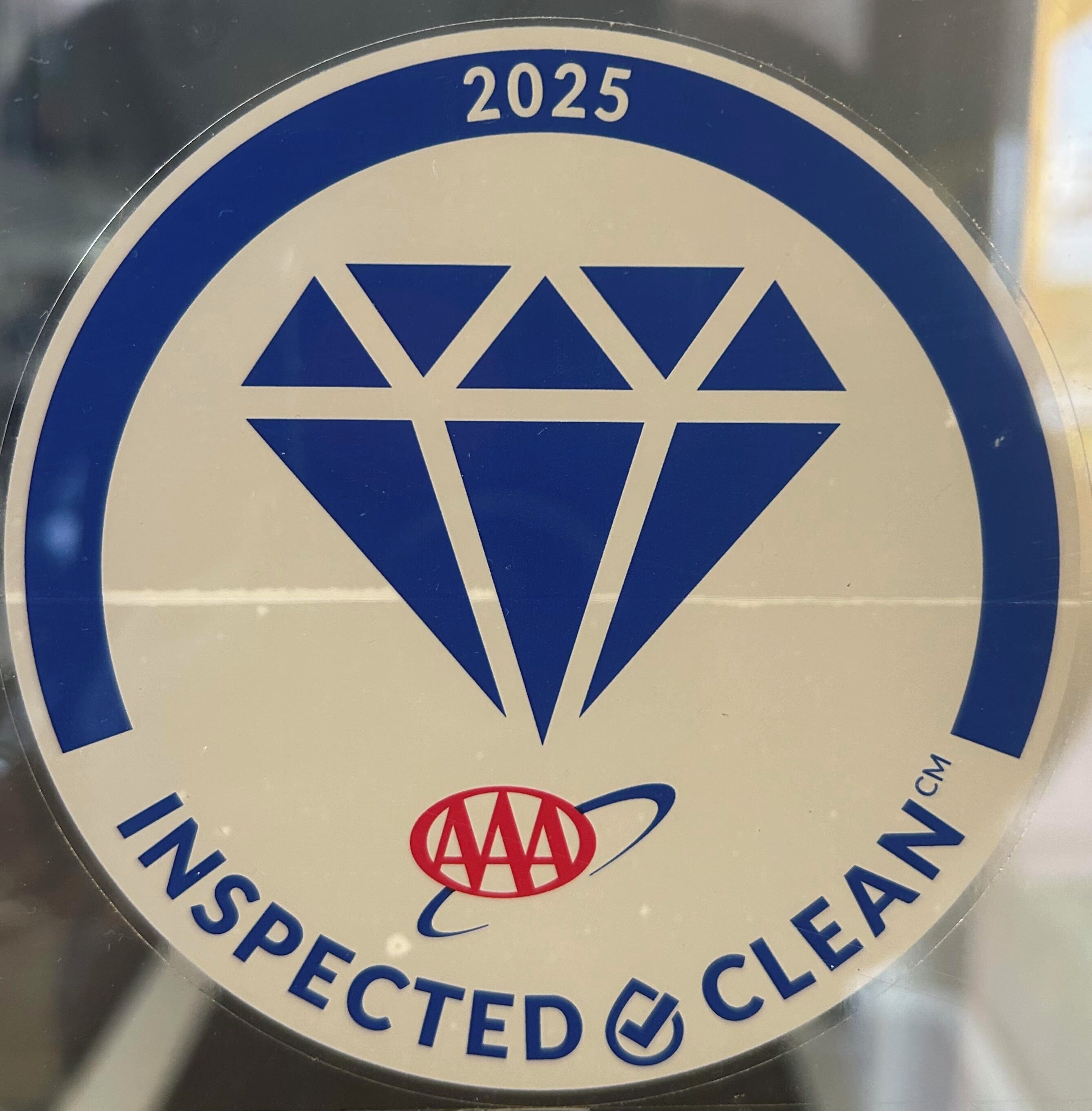 Ein runder Aufkleber mit einem Diamantenmuster, dem Jahr 2025 und dem Text „INSPECTED CLEAN“ sowie einem Logo.