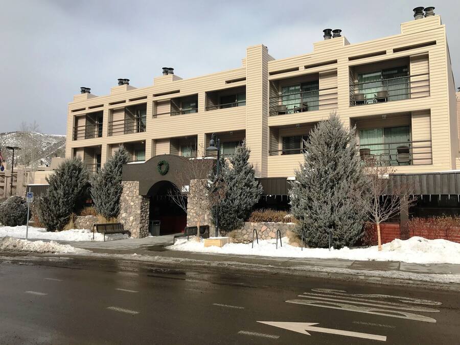 A multi-story building with a central entrance, balconies, and a snow-covered landscape.