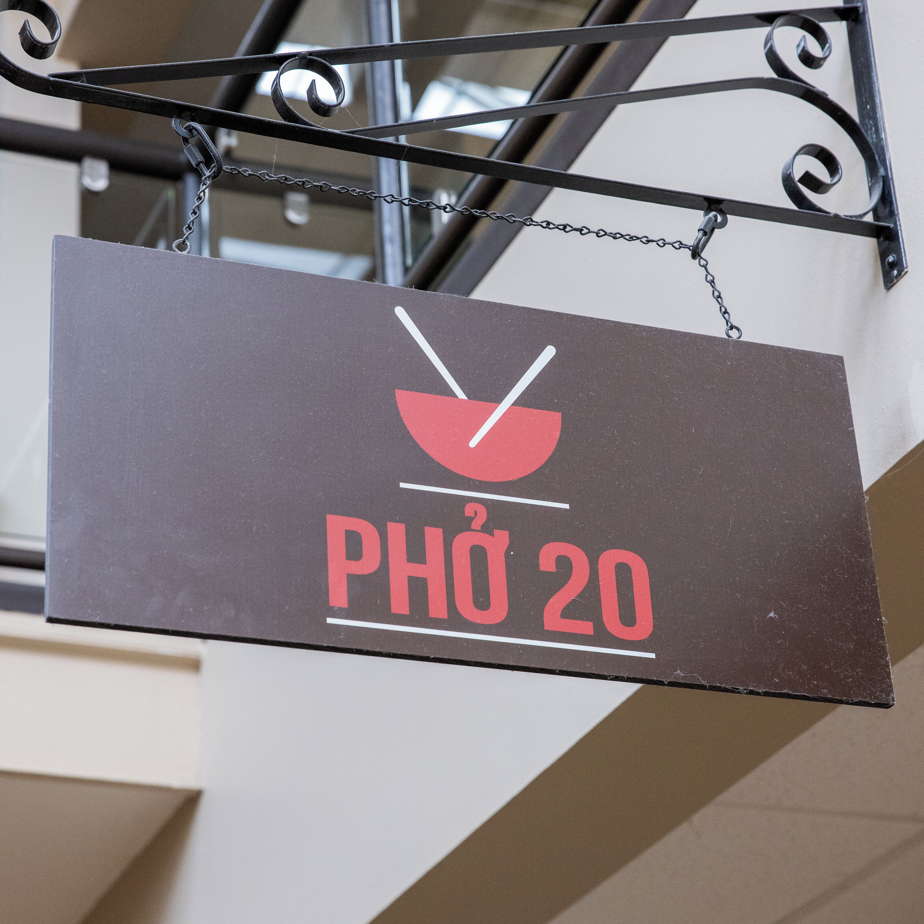 Een bord met een rood-wit ontwerp, waarop een lepel en de tekst 'PHÒ 20' staan.