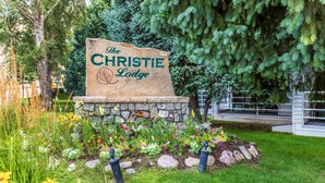 A stone sign with the text "The Christie Lodge" surrounded by a garden with various plants and flowers. - The Christie Lodge - All Suite Property, Vail Valley/Beaver Creek (Avon)