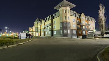 Een meerlaags hotel met een opvallende hoektoren, een parkeerplaats en een zichtbaar bord met 'SAVERIDGE INN'.