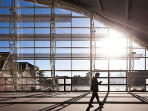 A spacious indoor area with large windows and a metal framework structure. - Novotel Belfort Centre Atria (Belfort)