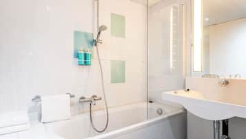 A modern bathroom with a bathtub, shower, and sink.