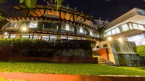 A modern building with a curved structure, large windows, and a well-maintained garden. - Hotel Victoria Oaxaca (Oaxaca)