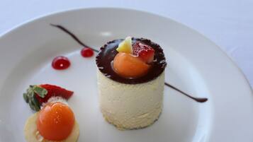 A dessert on a white plate with chocolate sauce, a strawberry, and a cherry.