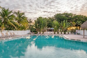 A swimming pool with lounge chairs and palm trees. - Holiday Inn Express Cape Coral-Fort Myers Area by IHG (Cape Coral)