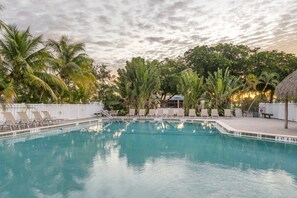 Una piscina al aire libre, sillones reclinables de piscina