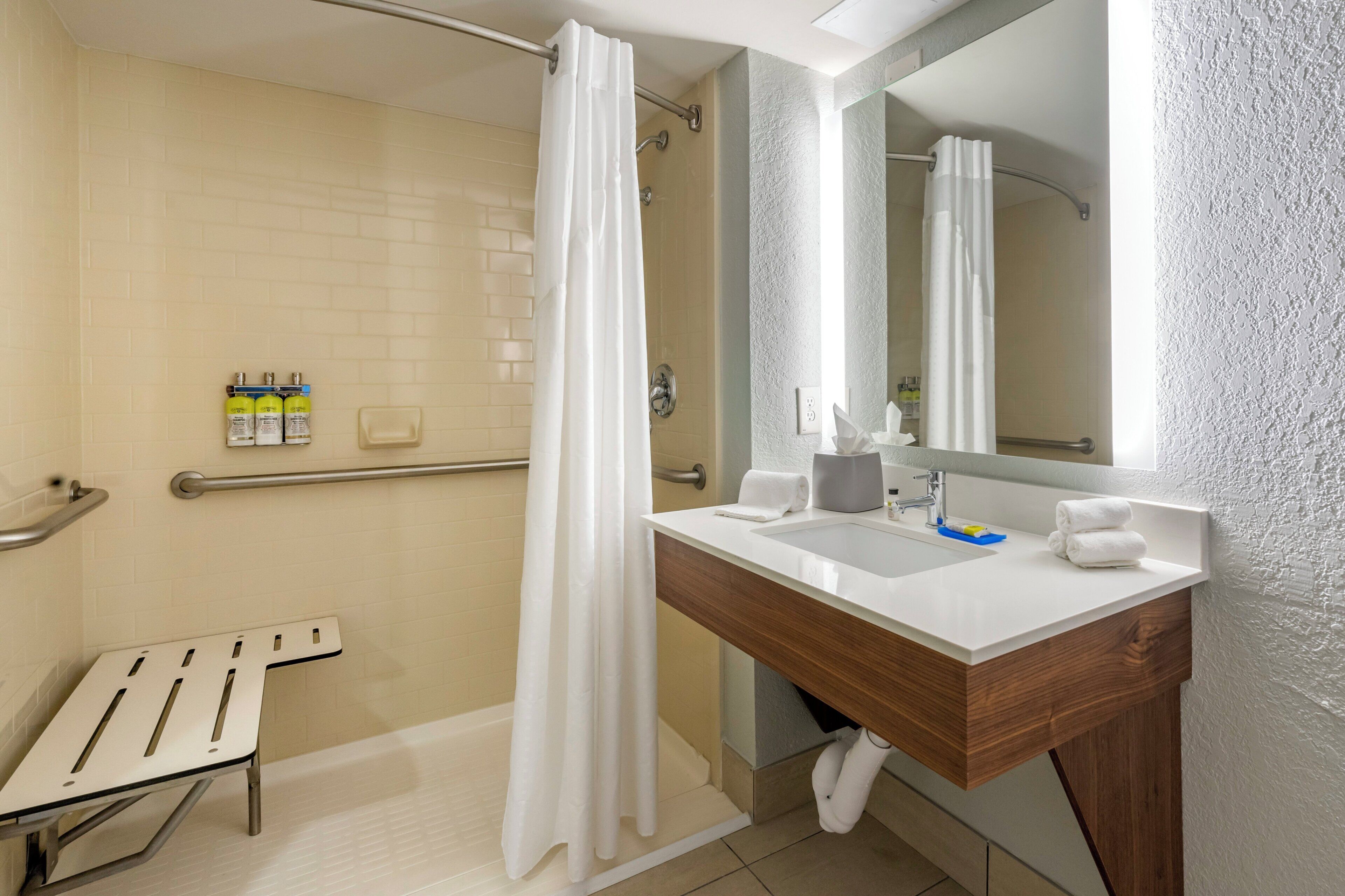 Un baño moderno con ducha, lavabo y espejo.