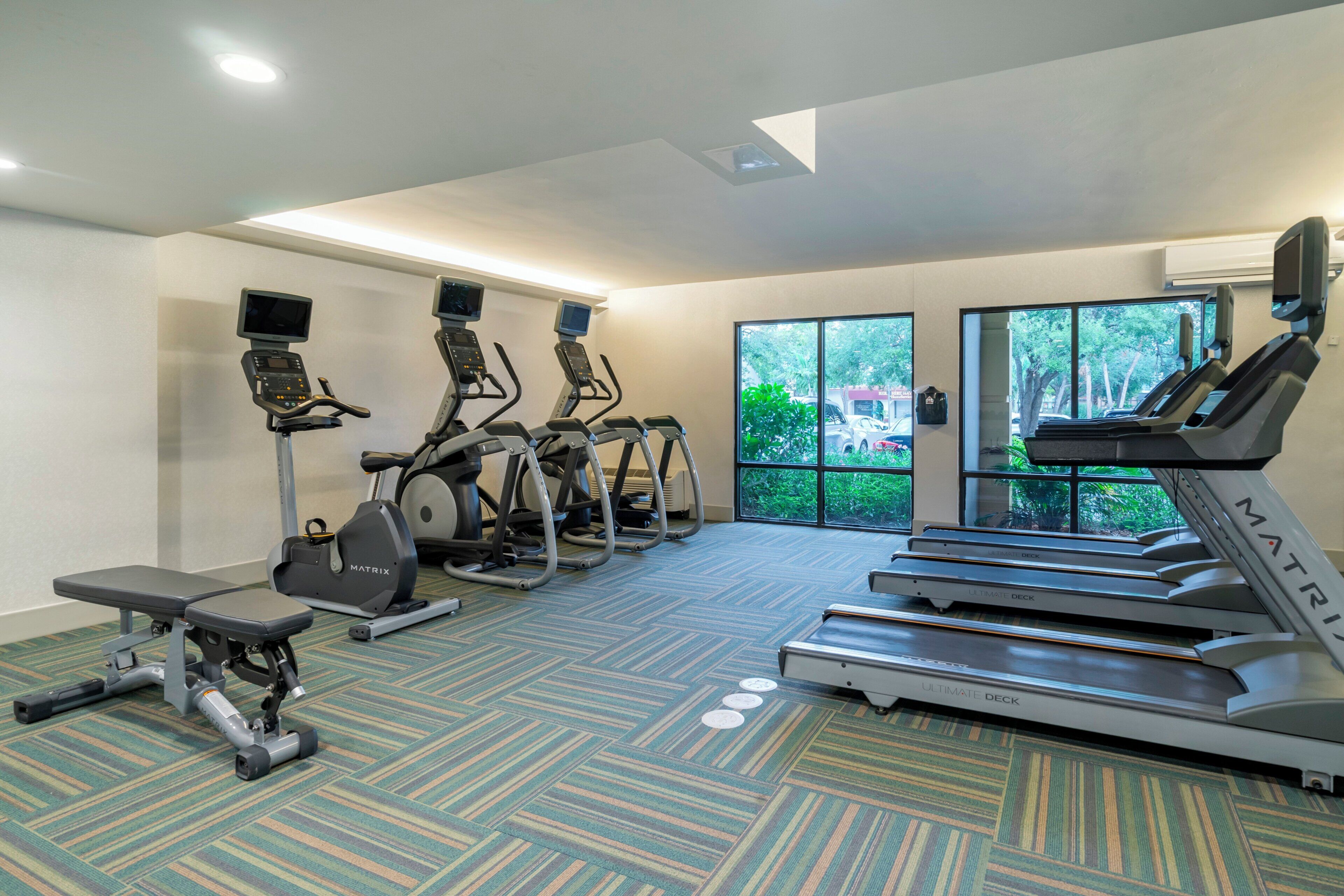 A gym with treadmills, elliptical machines, and a stationary bike.