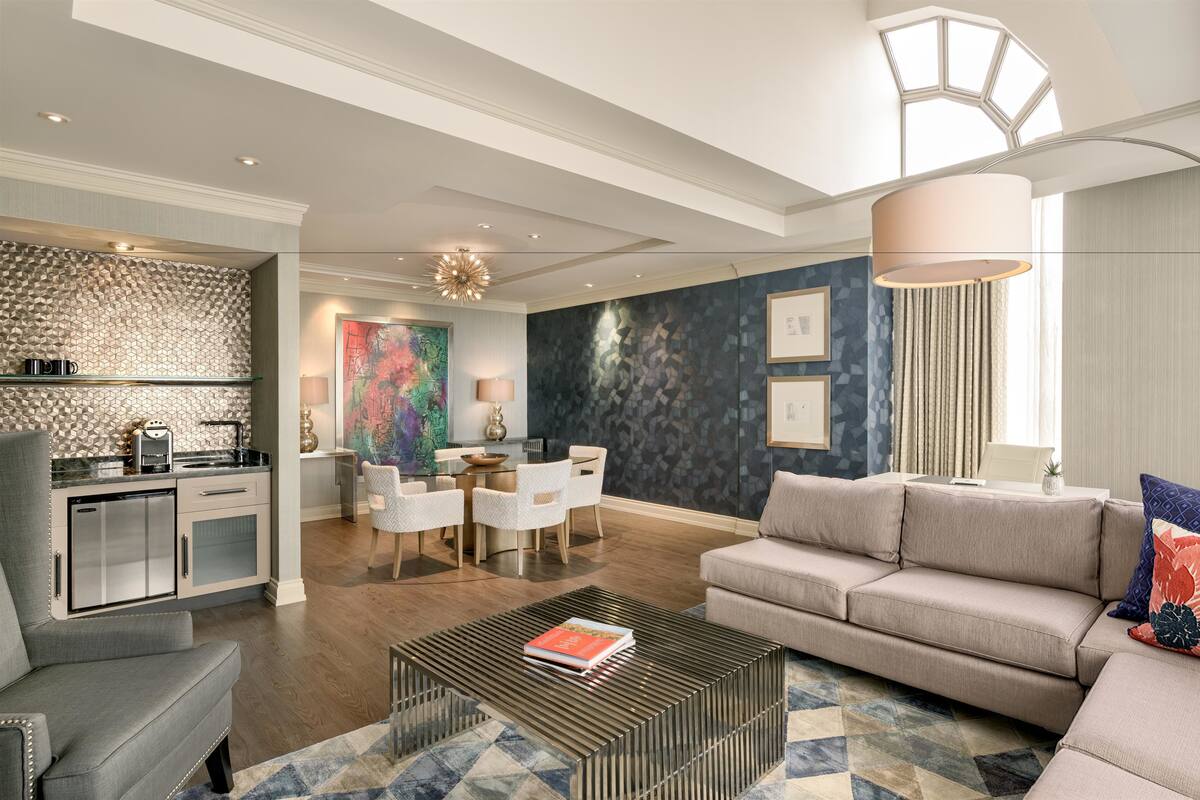 A modern living room with a sofa, coffee table, and dining area.