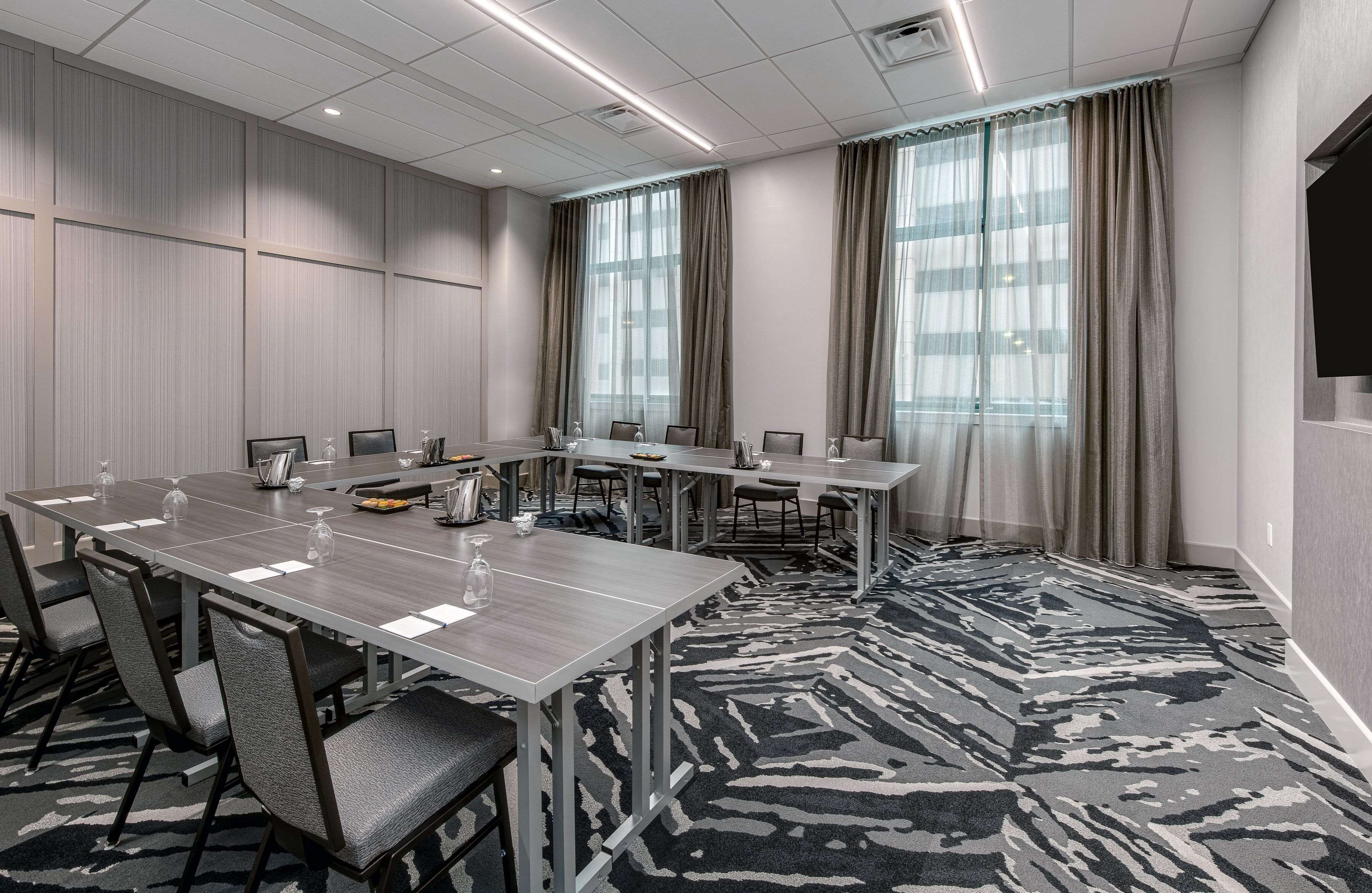 Une salle de conférence avec une longue table, des chaises et un sol recouvert de moquette.