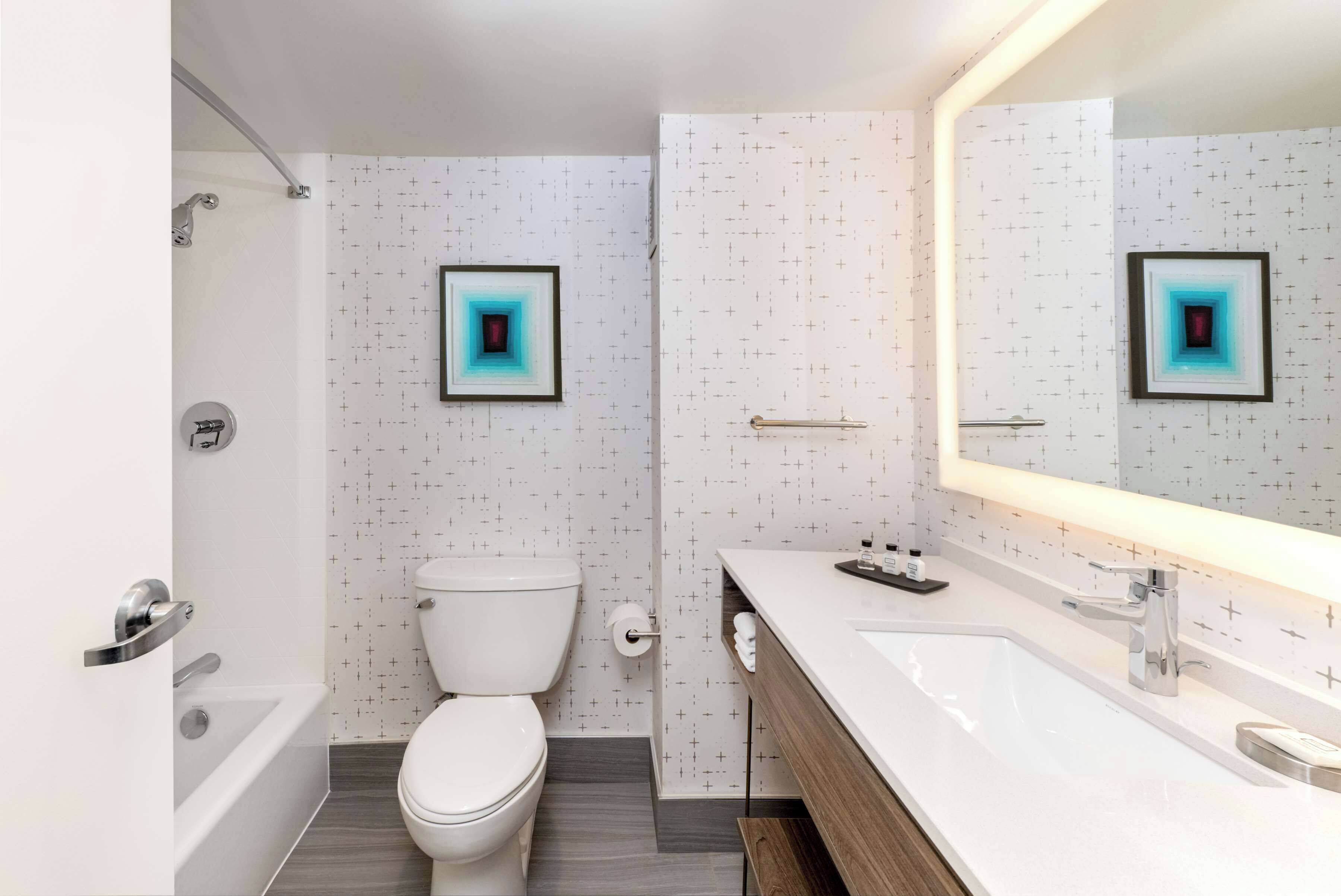 Ein modernes Badezimmer mit Toilette, Badewanne und Waschtisch mit Spiegel.