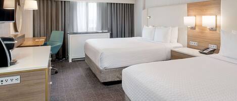 A hotel room with two beds, a desk, a chair, a TV, and a window with curtains.