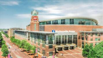 A large, modern building with a curved glass facade and a prominent sign reading "Nationwide Arena."