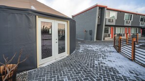 A modern building with a grey facade, a red roof, and a black tiled entrance area. - Hotel Rapids (Grand Rapids)