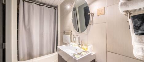 Et moderne badeværelse med badekar, et toiletbord med vask, et spejl og en bøjlestang til håndklæder.
