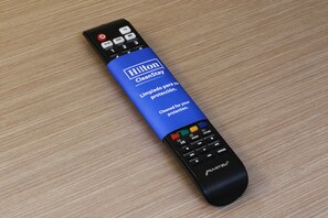 Ένα μαύρο τηλεχειριστήριο με μια μπλε ετικέτα στην οποία αναγράφονται οι λέξεις «Hilton CleanStay» και «Limpia para su protección».