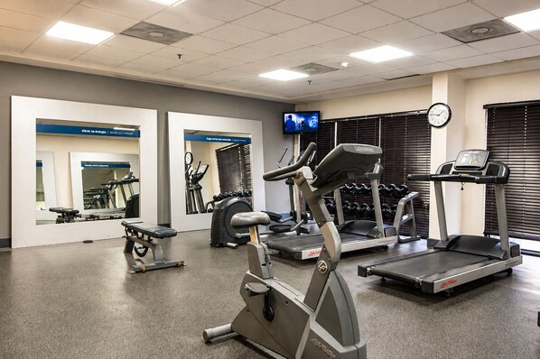 A gym with treadmills, an elliptical, and a bench.