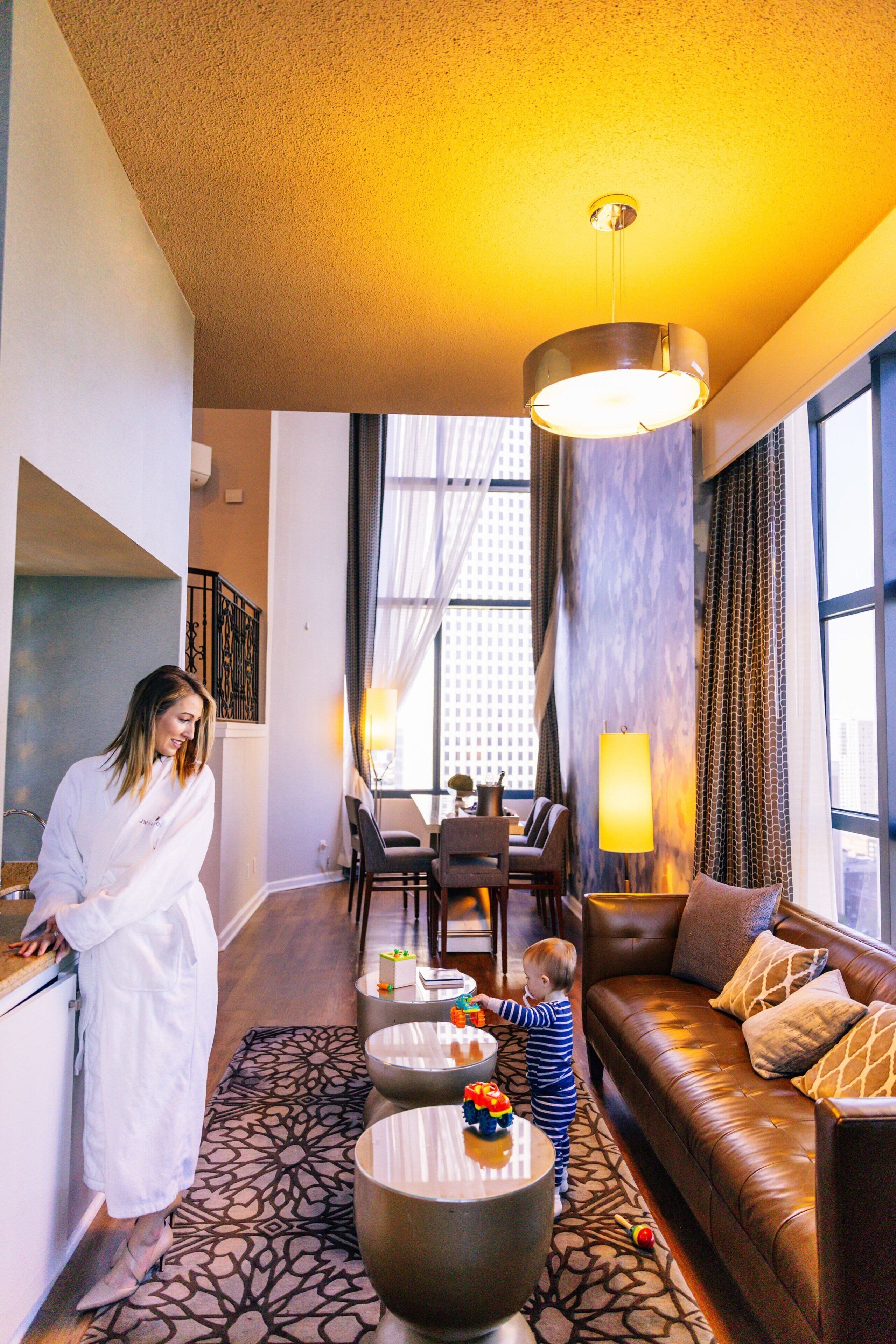 Une chambre d’hôtel avec un coin repas, un canapé et une grande fenêtre.