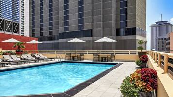 Una piscina al aire libre, sombrillas, tumbonas