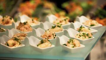 A glass table with neatly arranged food items in white bowls, garnished with herbs.