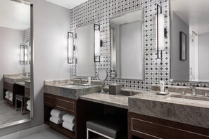 A modern bathroom with two sinks, marble countertops, and a patterned backsplash.