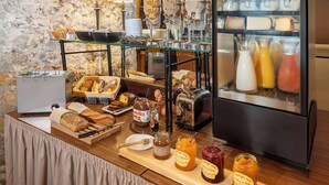 Un bufé de desayuno con panes, pasteles y mermeladas variados.