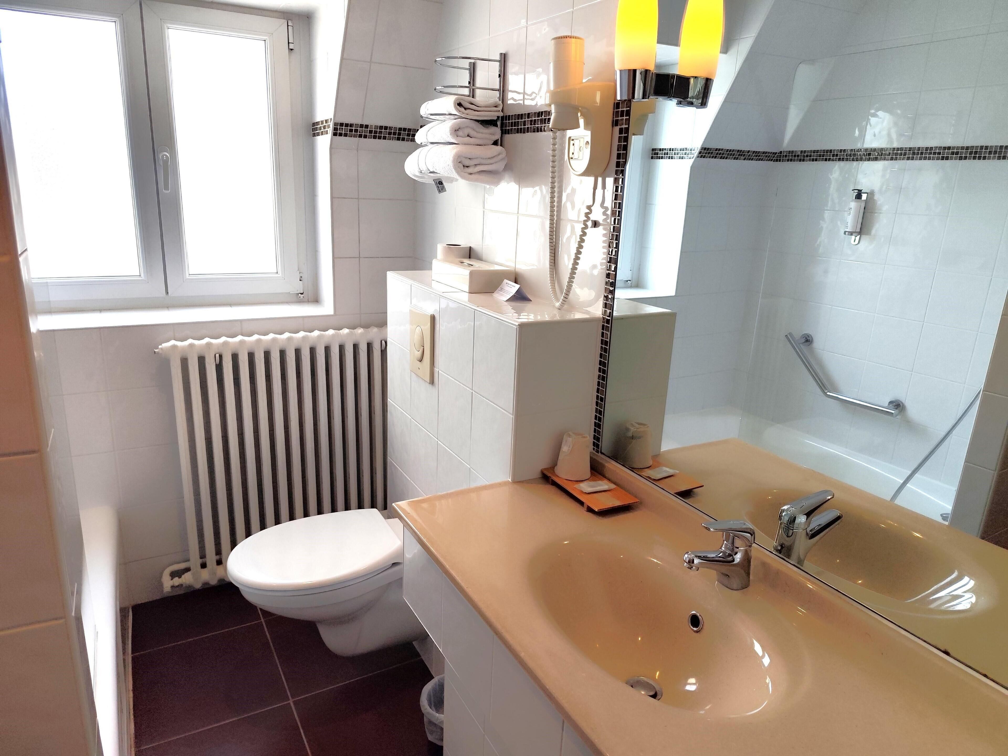 A bathroom with a toilet, sink, and shower.