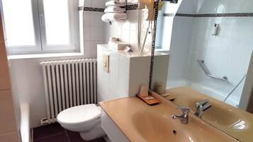 A bathroom with a toilet, sink, and shower.
