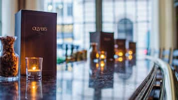 A bar area with a dark-colored box labeled "OLIVER'S" and a lit candle in a glass holder.