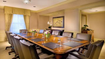 A conference room with a long table, chairs, and a fireplace.