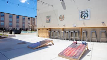 An outdoor seating area with a pool, bar stools, and a mural of Route 66.